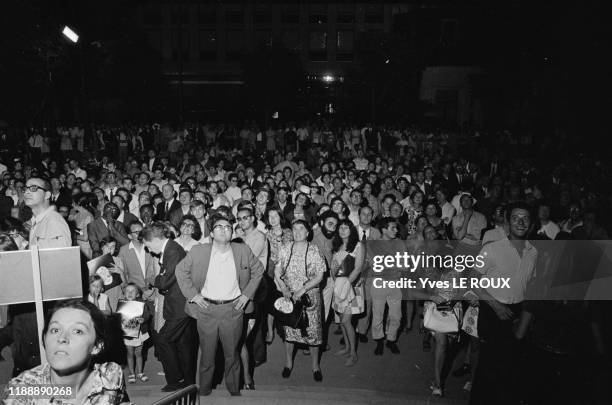 La foule regarde les images les astronautes de la mission Apollo XI marchés sur la lune dans la nuit du 20 au 21 juillet 1969, Paris, France.