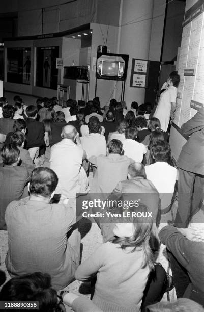 La foule regarde les images les astronautes de la mission Apollo XI marchés sur la lune dans la nuit du 20 au 21 juillet 1969, Paris, France.
