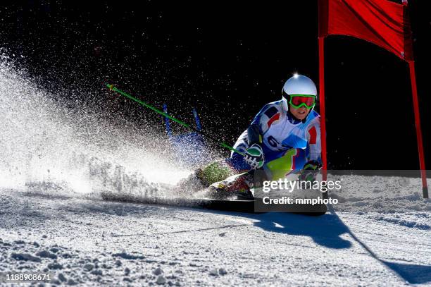 back lit shot of young adult alpine skier practicing giant slalom - ski slalom stock-fotos und bilder