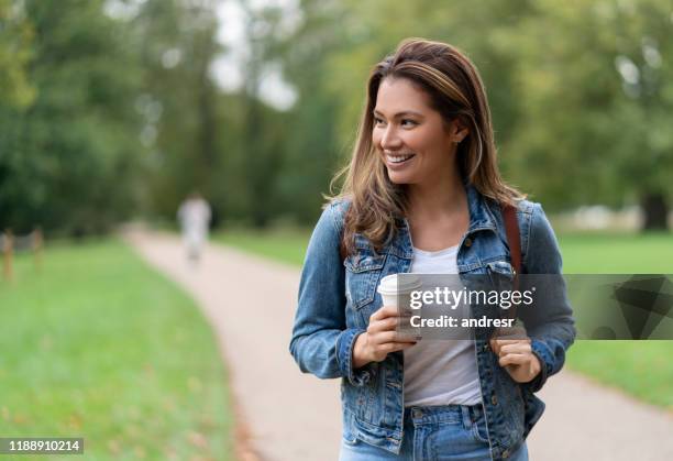 gelukkige vrouw ontspannen in het park het drinken van een kopje koffie - coffe to go stockfoto's en -beelden