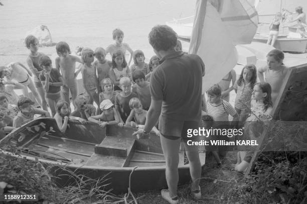 Un moniteur de voile explique les rudiments de la navigation à des jeunes enfants dans un centre de vacances près de Briançon en juillet 1974, France.