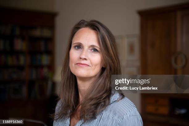 portrait of a beautiful mature woman in living room - einzelne frau über 40 stock-fotos und bilder