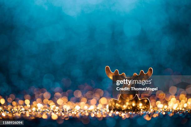 christmas reindeer - defocused decoration gold blue bokeh - winter and warm glow stock-fotos und bilder