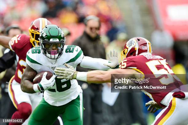 Le'Veon Bell of the New York Jets runs with the ball against Cole Holcomb of the Washington Redskins in the first half at FedExField on November 17,...
