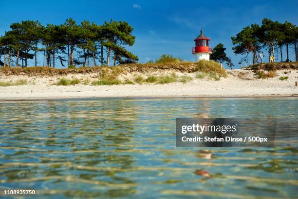 view of sea, beach and lighthouse, hiddensee, germany - hiddensee stock-fotos und bilder