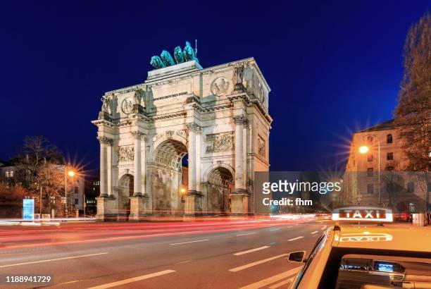 munich siegestor at blue hour wth taxi-sign (bavaria, germany) - munich landmark stock pictures, royalty-free photos & images