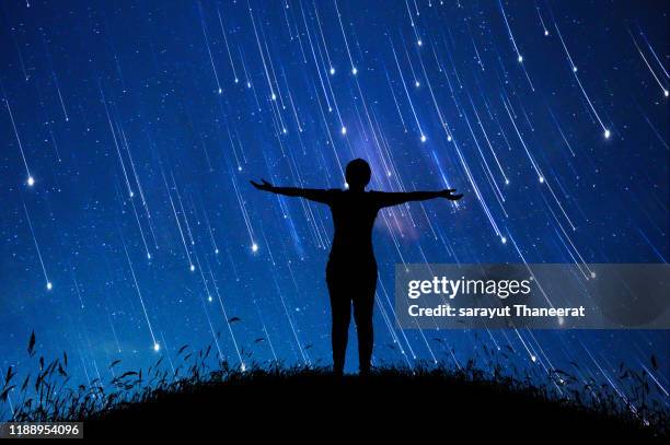 a girl standing in the midst of the stars at night with a meteor full of sky, concepts, imaginations, dreams - meteor stock pictures, royalty-free photos & images