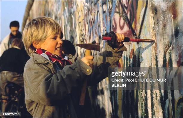 Boy chips at the Berlin wall on November 12, 1989 in Berlin, Germany.