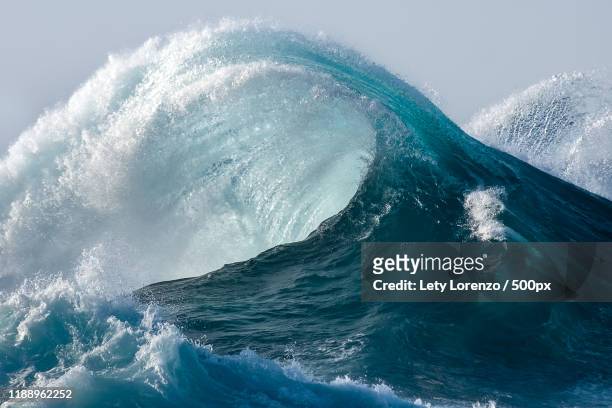 large wave splashing in blue sea - ola fotografías e imágenes de stock