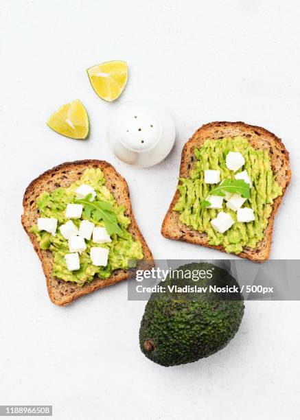 whole grain toast with avocado and feta cheese - queso de cabra fotografías e imágenes de stock