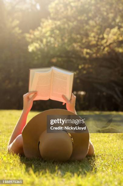 enloquecida en su libro favorito - mujer leyendo libro en el parque fotografías e imágenes de stock