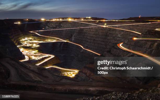 vehicle light trails along winding roads surrounding fimiston open pit at dusk, kalgoorlie, western australia, australia - kalgoorlie stock pictures, royalty-free photos & images
