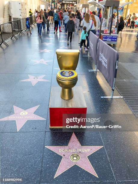 Golden toilet created by a political street artist is left near the star of Donald Trump on the Hollywood Walk of Fame on December 15, 2019 in...