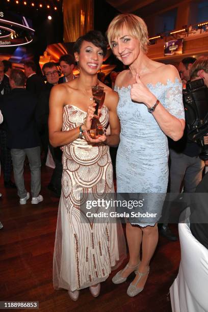 Long jump gold medalist Malaika Mihambo with award and former long jumper Heike Drechsler during the 'Sportler des Jahres 2019' Gala at Kurhaus...