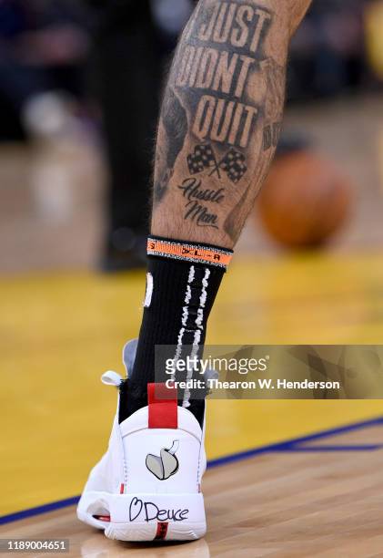 Detailed view of the tattoos "I Just Don't Quit" on the calf and the Nike Air Jordan's with a heart and the name "Deuce' on the back worn by Jayson...