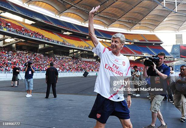 Arsene Wenger manager of Arsenal waves to the crowd during an open training session during the club's pre-season Asian tour at the Bukit Jalil...