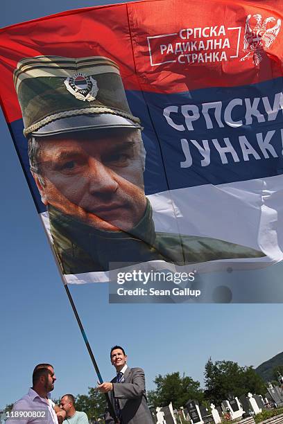 Supporter of the Serbian Radical Party waves a flag that depicts Ratko Mladic, former Chief of Staff of the Bosnian Serb army and currently on trial...