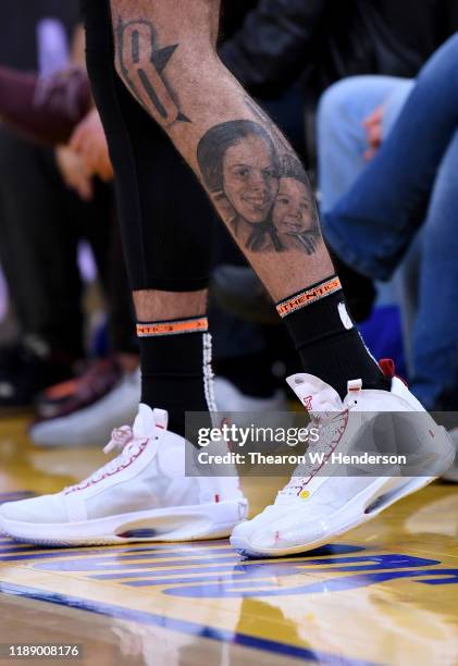 Detailed view of the tattoos "I Just Don't Quit" on the calf and the Nike Air Jordan's with a heart and the name "Deuce' on the back worn by Jayson...