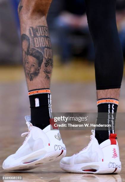 Detailed view of the tattoos "I Just Don't Quit" on the calf and the Nike Air Jordan's with a heart and the name "Deuce' on the back worn by Jayson...