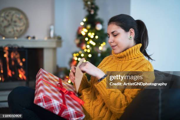 mujer abriendo regalo de navidad. - receiving fotografías e imágenes de stock