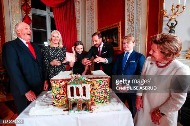King Harald, Crown Princess Mette-Marit, Princess Ingrid Alexandra, Crown Prince Haakon, Prince Sverre Magnus and Queen Sonja admire the gingerbread...
