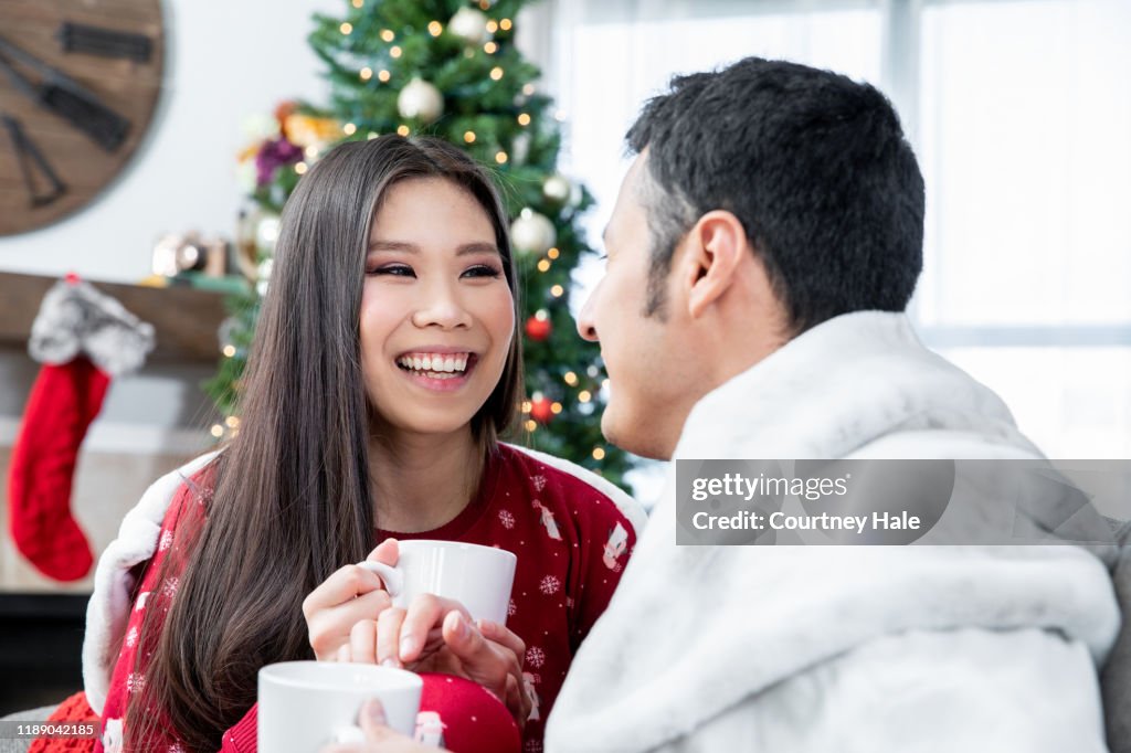 Young couple enjoying coffee on cozy Christmas morning