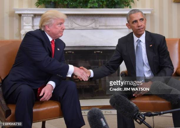 In this file photo taken on November 10 US President Barack Obama and President-elect Donald Trump shake hands during a transition planning meeting...
