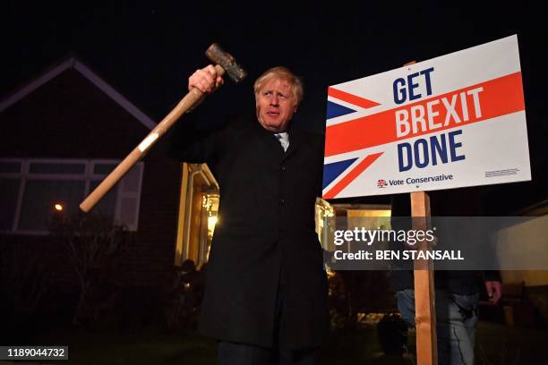 In this file photo taken on December 11 Britain's Prime Minister and Conservative party leader Boris Johnson poses after hammering a "Get Brexit...