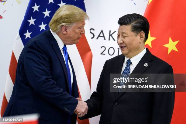 In this file photo taken on June 28 China's President Xi Jinping shakes hands with US President Donald Trump before a bilateral meeting on the...