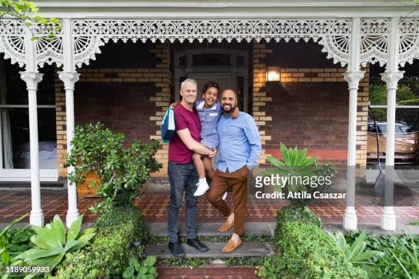 happy dads and primary school age daughter standing in front of house - melbourne school stock pictures, royalty-free photos & images
