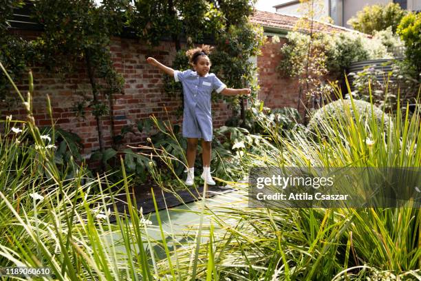 little schoolgirl jumping on trampoline - melbourne school stock pictures, royalty-free photos & images