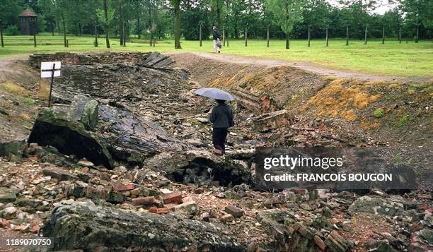 Une visiteuse marche parmi les ruines de l'une des chambres à gaz du camp d'extermination d'Auschwitz-Birkenau, le 08 août 2000 lors d'un voyage...