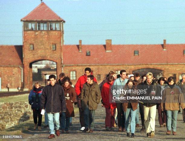 Un groupe de lycéens marche, le 01 mars devant la célèbre porte d'entrée du camp d'extermination d'Auschwitz - Birkenau, en Pologne. Les lycéens...