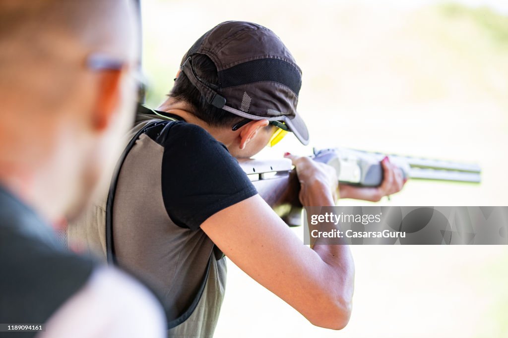 Erwachsene Frau Schießen mit einer Schrotflinte im Freien - Stock Foto