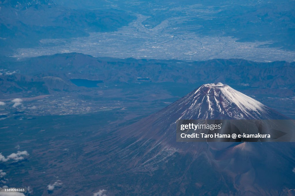 Snow-capped Mt. Fuji and Kofu city in Yamanashi prefecture of Japan aerial view from airplane