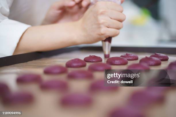 young asian woman using icing bag in bakery - icing bag stock pictures, royalty-free photos & images