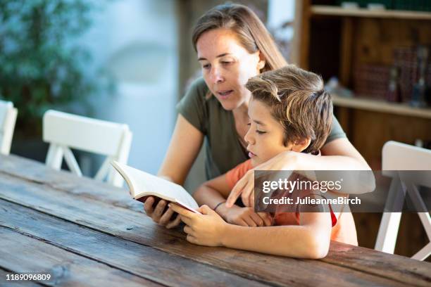 moeder en jonge zoon lezen hardop in eetkamer tafel - 10 11 jaar stockfoto's en -beelden