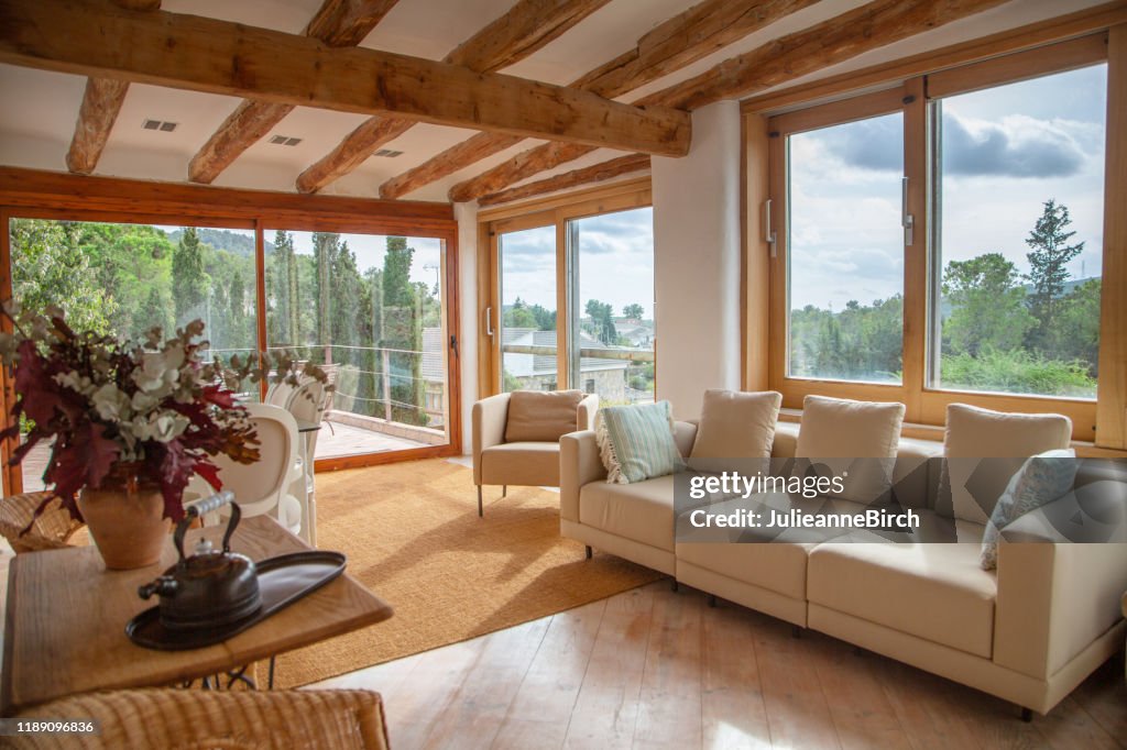 Upper living room view on to garden, pool and courtyard of Spanish farmhouse, Barcelona