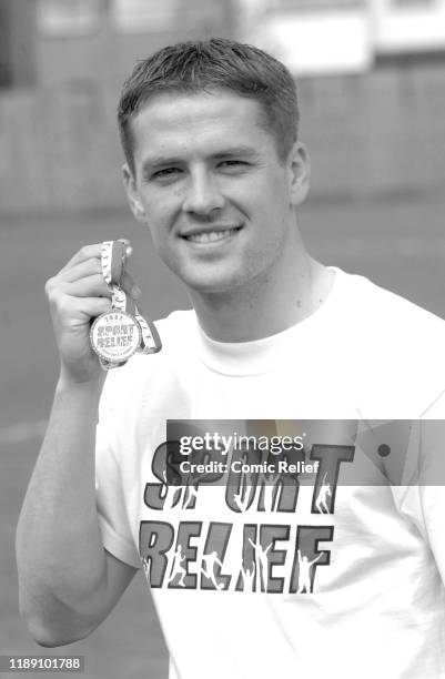 Black and white image of former footballer Michael Owen as he poses with a sport relief medal for the launch of sport relief 2002 in London, England.