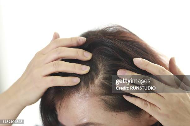 close up of middle aged woman checking hair - thin hair stock pictures, royalty-free photos & images