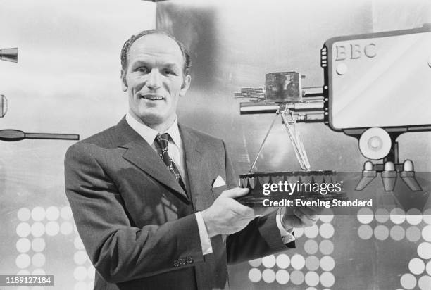 British heavyweight boxer Henry Cooper holds up the 1970 BBC Sports Personality of the Year Award after being presented with the trophy at the annual...