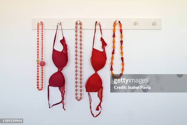 necklaces and bras hanging on rack - bra stock pictures, royalty-free photos & images