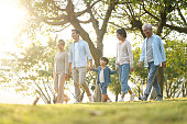 three generation family walking outdoors in park