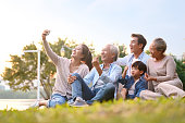 three generation asian family taking selfie outdoors
