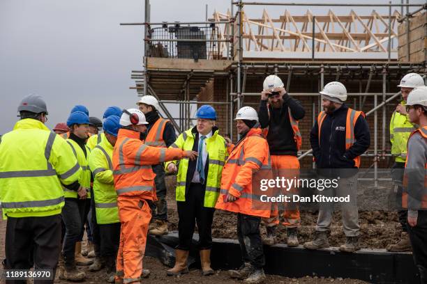 Prime Minister Boris Johnson jokes with builders during a visit to the Barratt Homes - Willow Grove housing development on November 21, 2019 in...