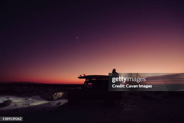 girl on top of the 4x4 during the blue hour - wild overland stockfoto's en -beelden