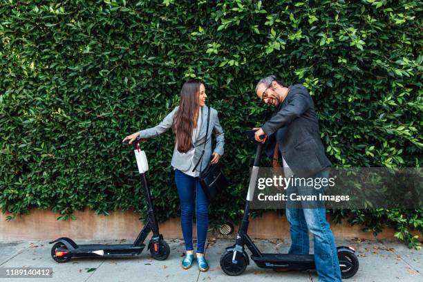 man and woman with electric scooter - x世代 ストックフォトと画像