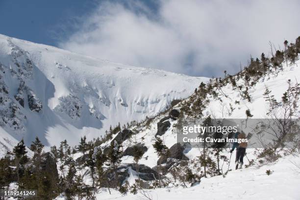 a woman skiing in fresh powder near tuckerman ravine on mount washington in the white mountains of new hampshire. - ホワイト山脈 ストックフォトと画像