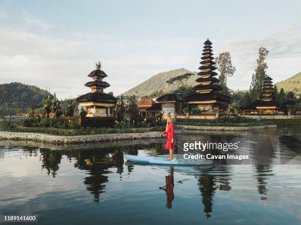 female sup surfer at bratan lake - indonesia surfing stock pictures, royalty-free photos & images