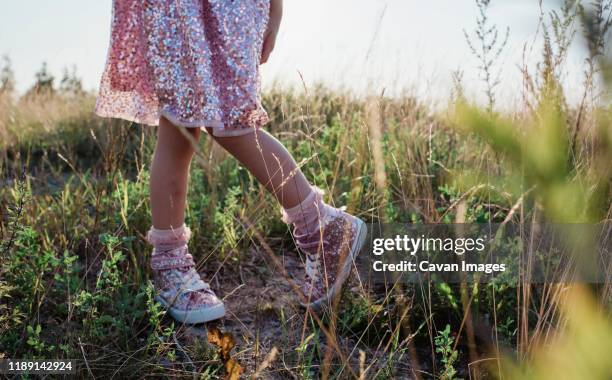young girls sparkly shoes and dress in the middle of a field at sunset - glitter shoes stock pictures, royalty-free photos & images
